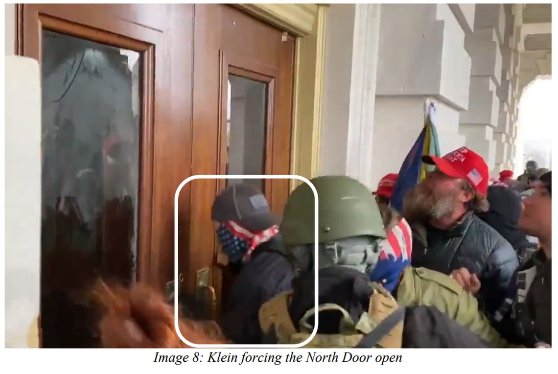 Jonathanpeter Klein, circled, is seen trying to force open the North Doors of the U.S. Capitol Building during the Jan. 6 riots. His brother Matthew Klein is seen directly behind him in the olive green jacket and American flag gaiter.