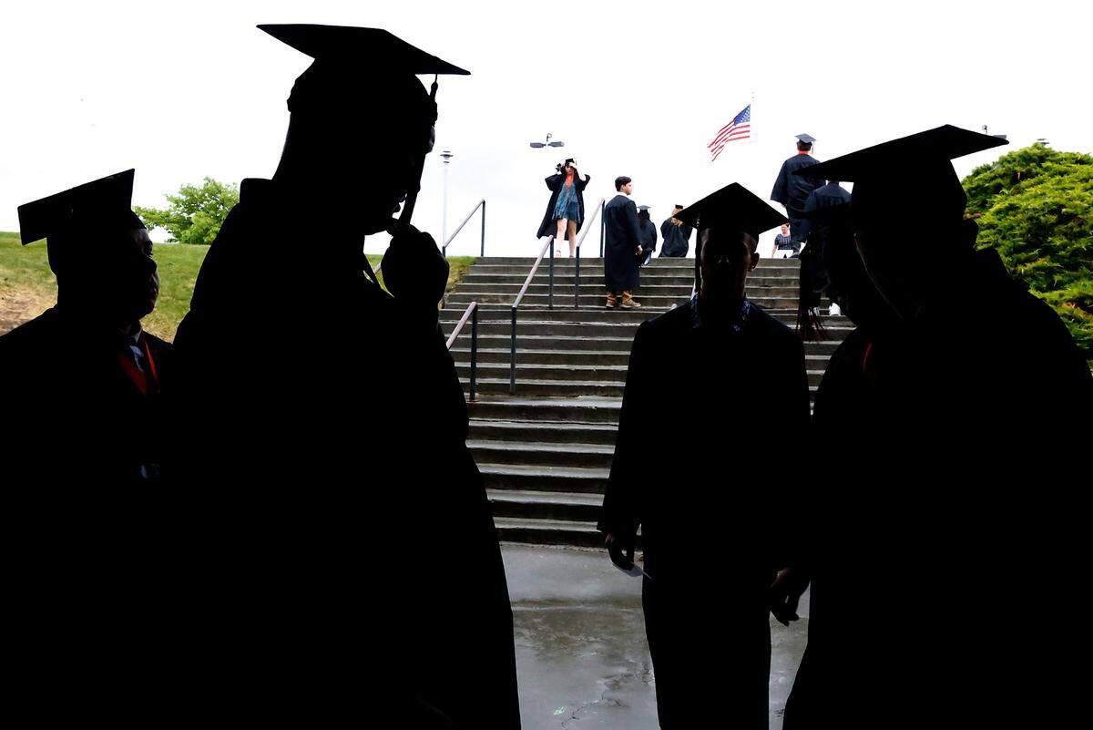 Graduates gather near an entrance to the Toyota Center for a commencement ceremony.