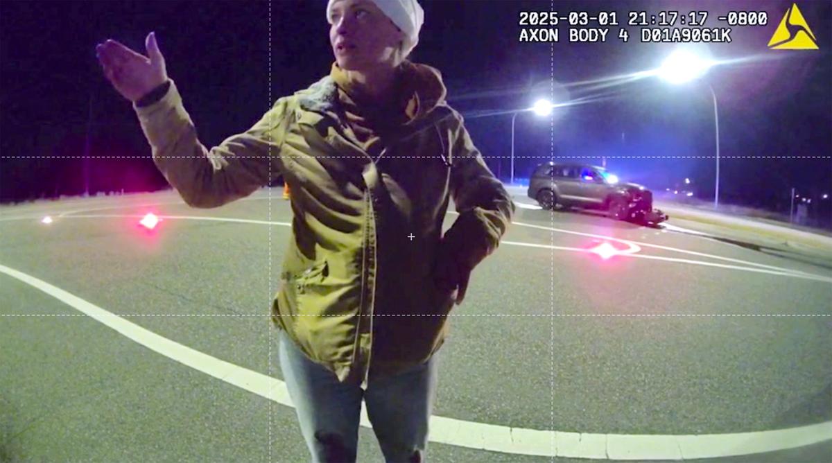 Sarah Clasen answers questions by Richland Police officer Steve Heid during his investigation of the March 1 fatal collision on Highway 240.