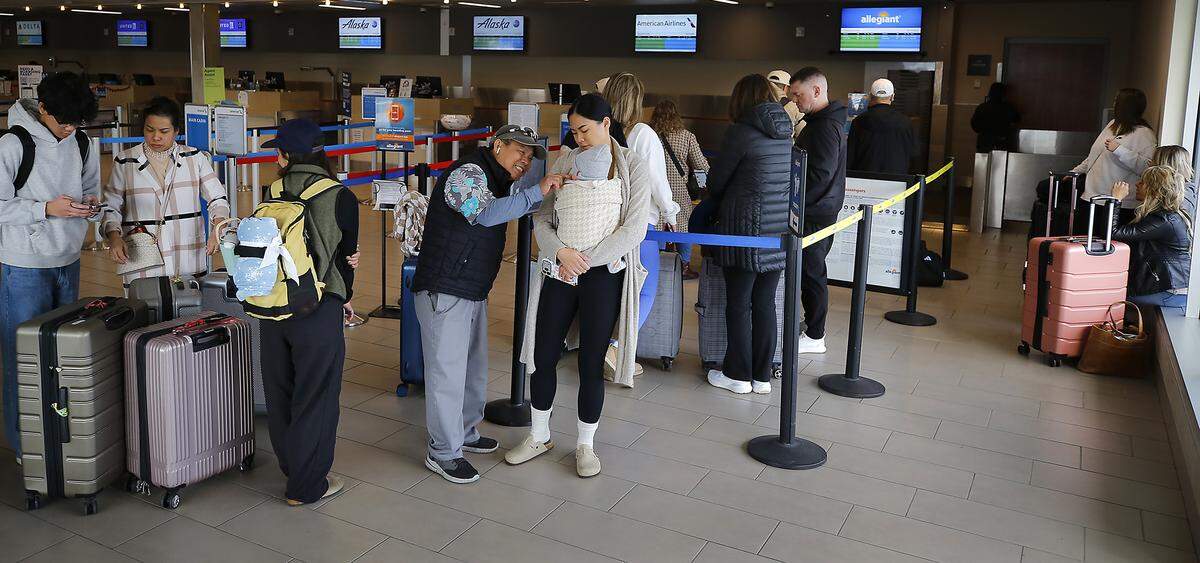 Passengers for the first flight of the new Allegiant Airlines flight to Orange County, CA, wait for the ticket counter to open Thursday at the Tri-Cities Airport in Pasco. 