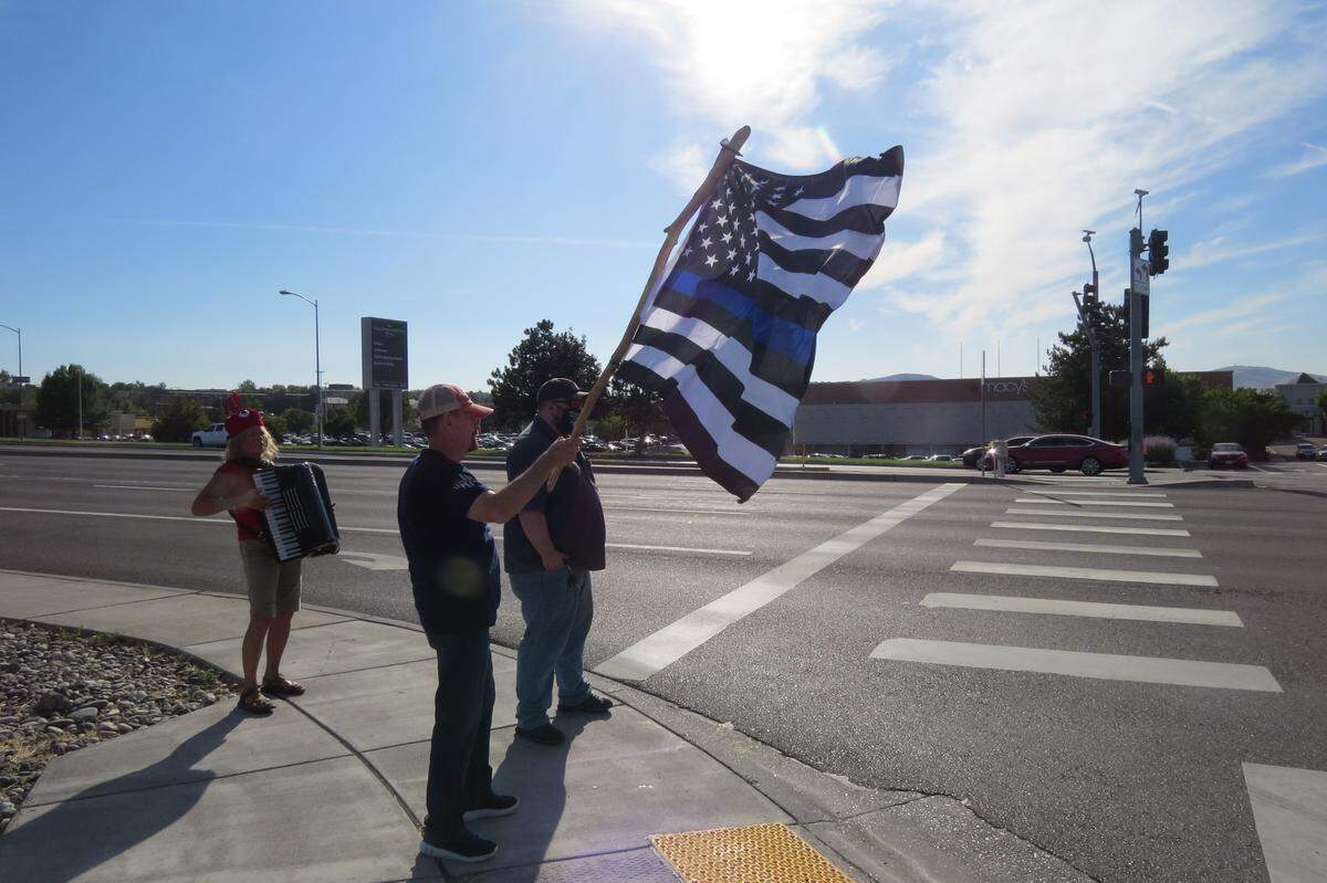 People from a “Back the Blue” counter-protest stood on the other side of the street with a flag.