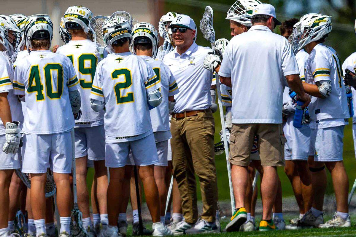 Richland head coach Chad Mitchell talks with the Bombers during a fourth-quarter timeout in Richland’s 18-4 playoff win over Juanita on Saturday at Fran Rish Stadium in Richland