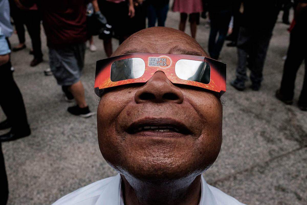Former Tri-Citian Mike McCawley, an award-winning street photographer in Chicago, documents everyday life, events and expressions, including this man watching the eclipse.