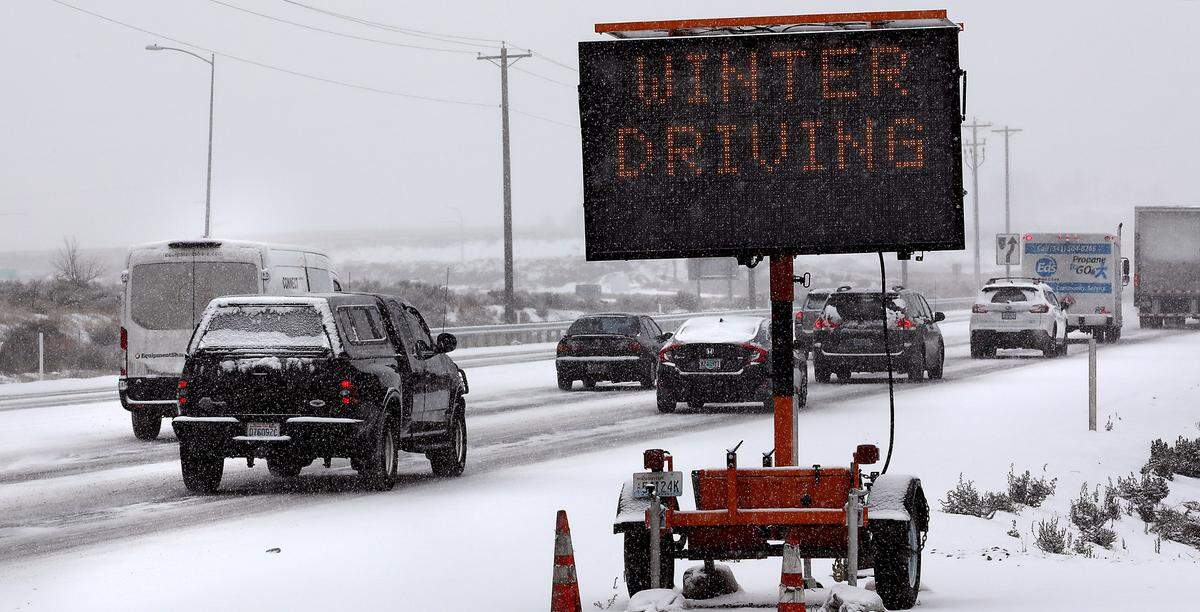 Drivers headed south on Highway 395 in Kennewick Thursday afternoon pass a WSDOT message board warning of winter driving conditions as falling snow coats the roadway. The Tri-Cities is under a winter weather advisory through Friday afternoon with 2 to 4 inches of snow expected by the National Weather Service.
