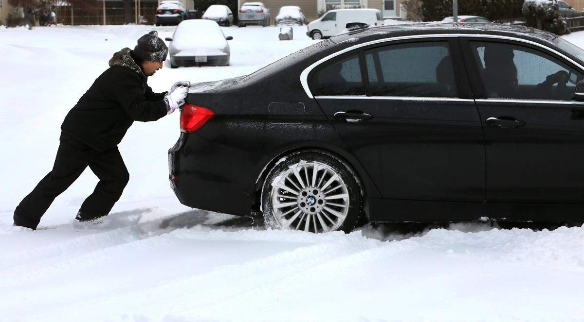 Good Samaritan Jose Morales helps free a stuck motorist early Friday at the intersection of South Conway Street and South Buntin Loop in Kennewick.