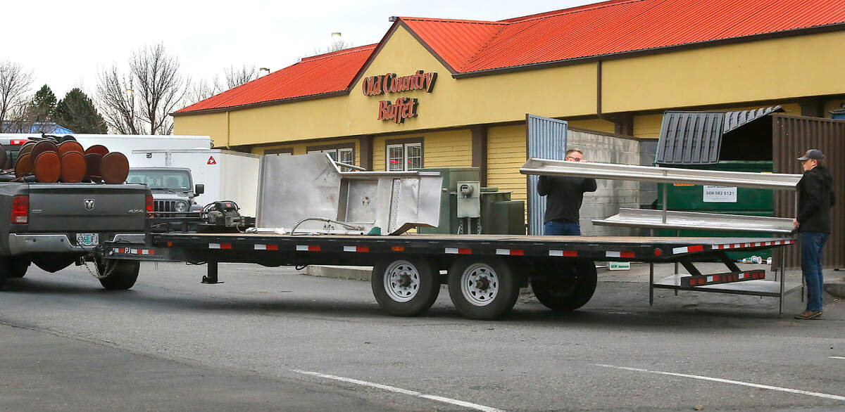 Successful bidders of an online auction remove their items, including stainless steel kitchen sinks, from the former Old Country Buffet Restaurant building on West Canal Drive in Kennewick.
