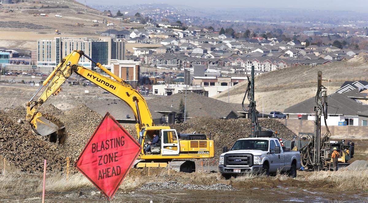 An excavator and drilling machines work in a field behind homes on West 48th Avenue at the south end of The Heights at Canyon Lakes neighborhood in Kennewick. Homeowners say their houses are being damaged by the construction work. Watch a video at: tricityherald.com/videos
