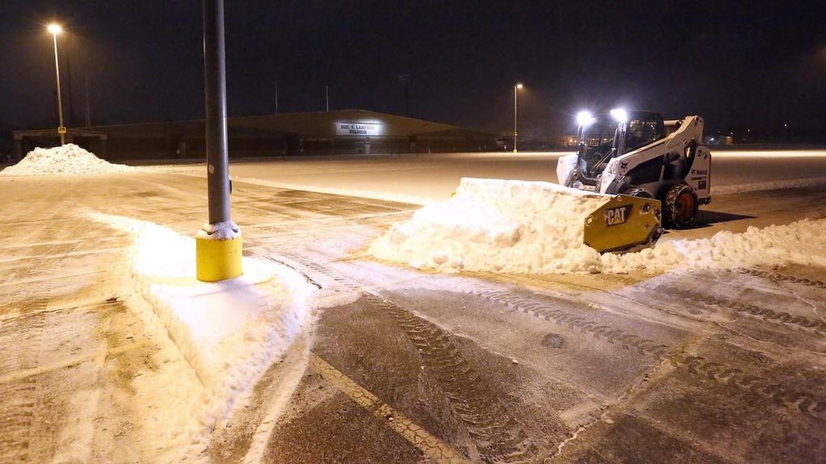 A Kennewick School District employee clears snow from the parking lot behind the Fruitland School building near Lampson Stadium early Wednesday morning. Many of the area school district's are opening after a two hour delay because of a blanket of snow that fell overnight. See at complete listings of closures at: www.tricityherald.com