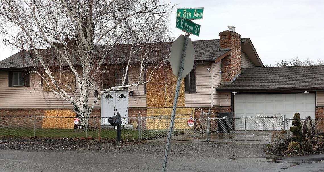 Sheets of plywood cover recently vandalized broken windows at the home in Kennewick that is being converted into housing for sex offenders leaving a special commitment center on McNeil Island.