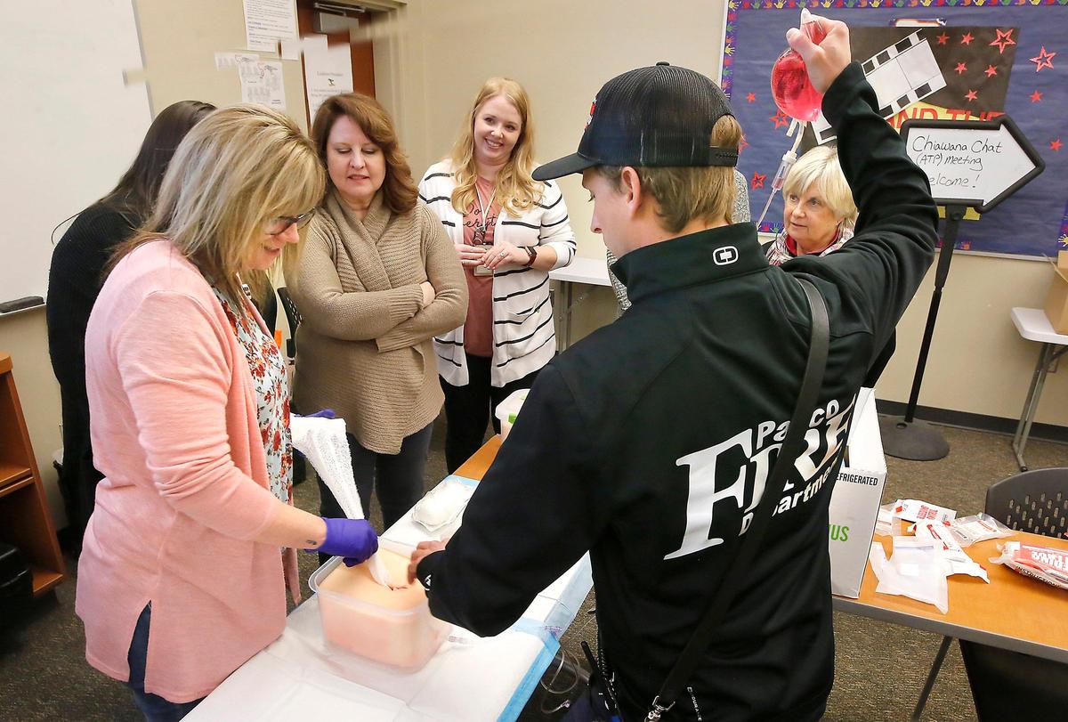 Pasco school nurse Billie Wensveen, left, and Pasco paramedic Ricky Micheles practice packing a bandage into simulated wound during a “Stop the Bleed’ trauma training session. Watch a video at: tricityherald.com/video