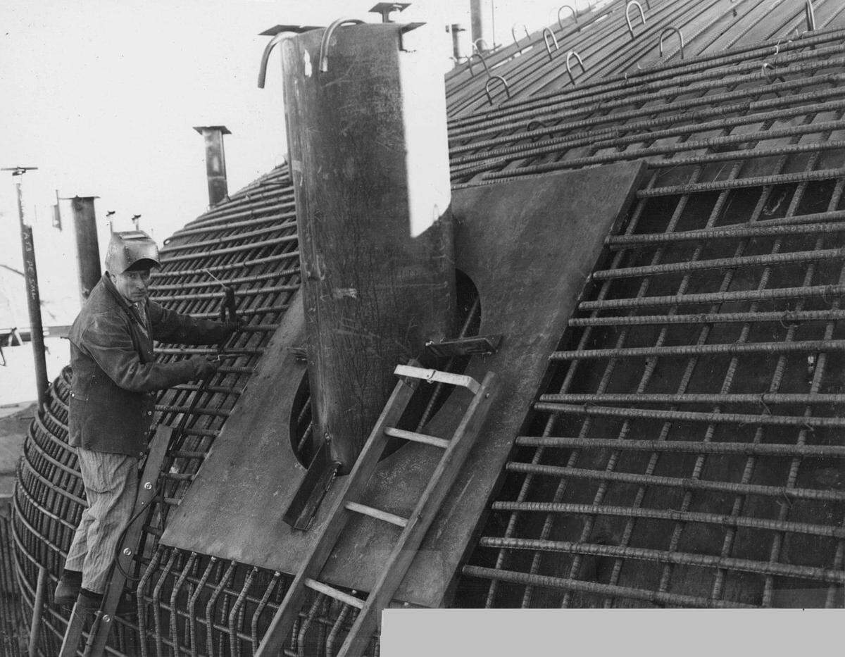 A historical Hanford site photo shows a man working on construction of an underground tank to hold radioactive waste at the Hanford nuclear reservation.