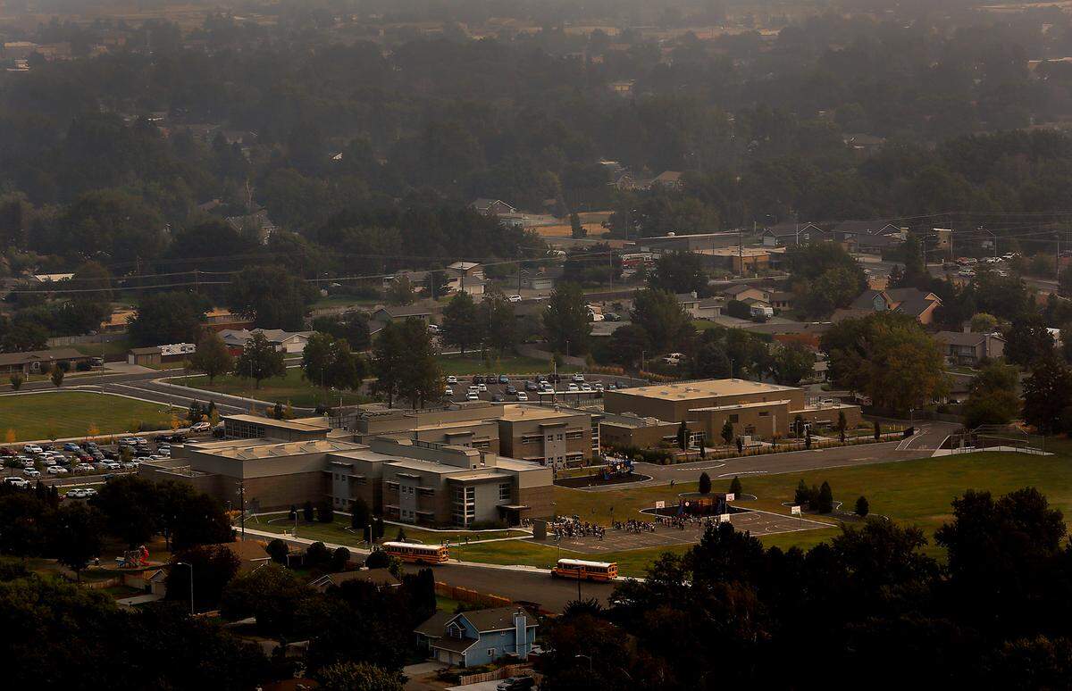 A layer of smoke from wildfires burning in the Pacific Northwest fills the air Monday morning as students arrive for classes at Fuerza Elementary School at 6011 W. 10th Pl. in Kennewick. Some Mid-Columbia school districts are cancelling student outdoor activities because of air quality concerns.