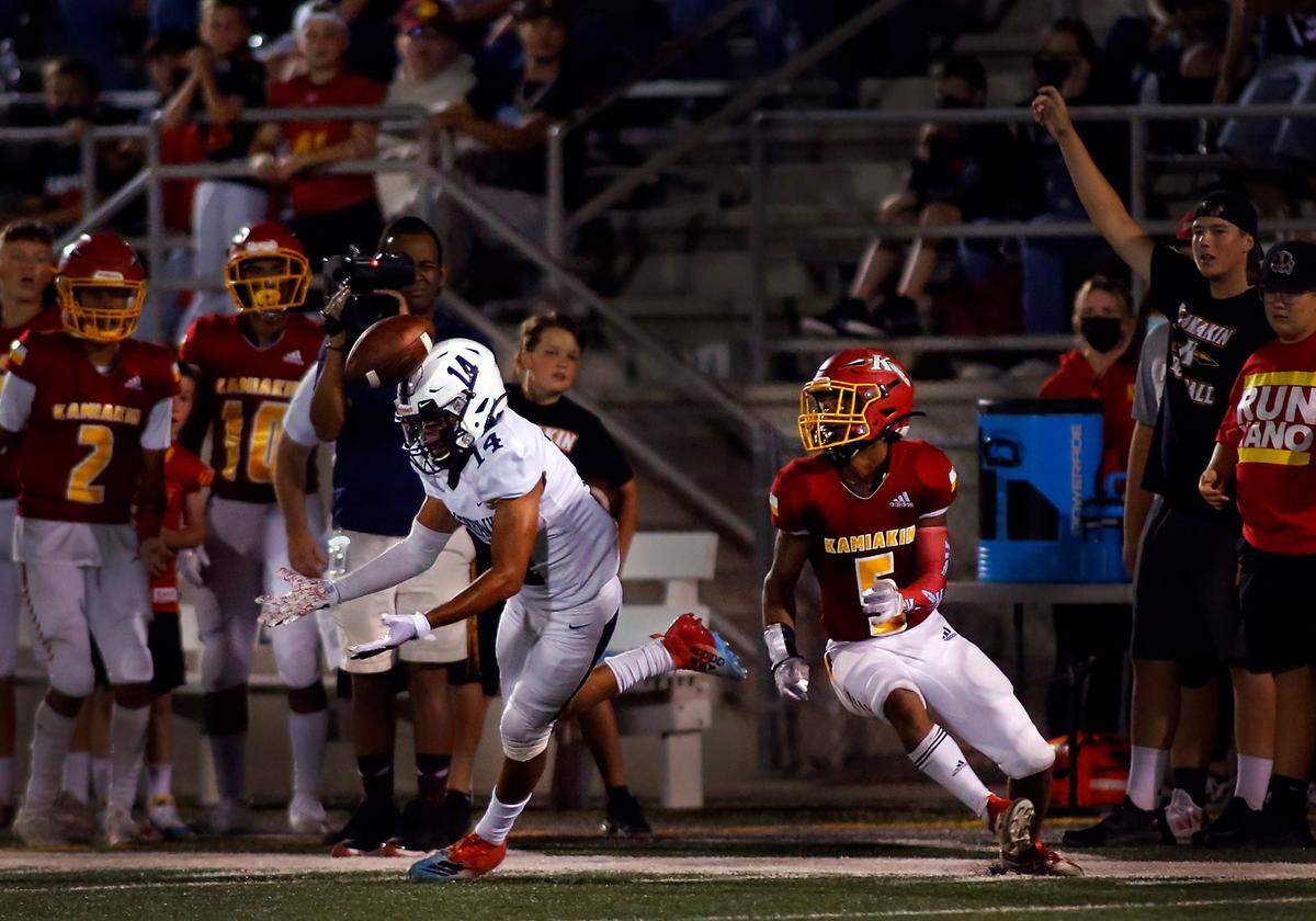 Chiawana’s William Whiting (14) can’t find the handle on this pass as Kamiakin defender Aidan Canada chases the play during Thursday’s game at Lampson Stadium in Kennewick. The Braves won 46-24.