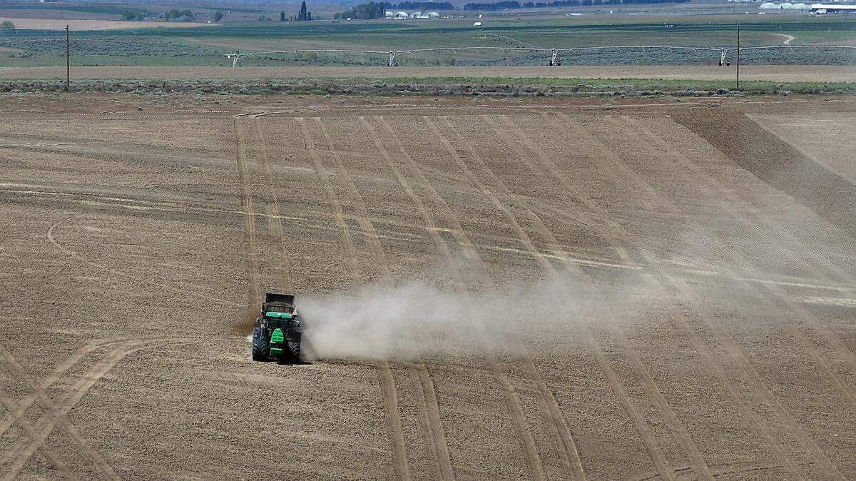 A tractor works in a field adjacent to Interstate 82 near Plymouth in Benton County south of Kennewick near the Oregon border.