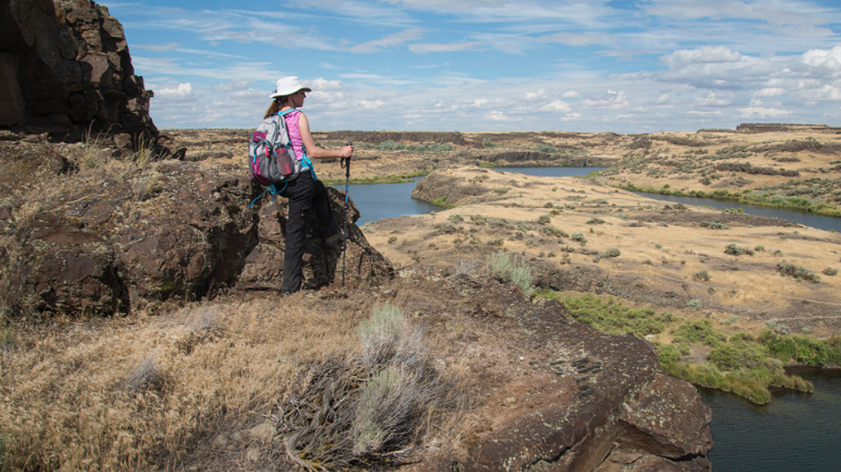 A hiker looks over the Drumheller Channels and their classic scabland topography from a ledge overlooking Black Lake north of Othello.