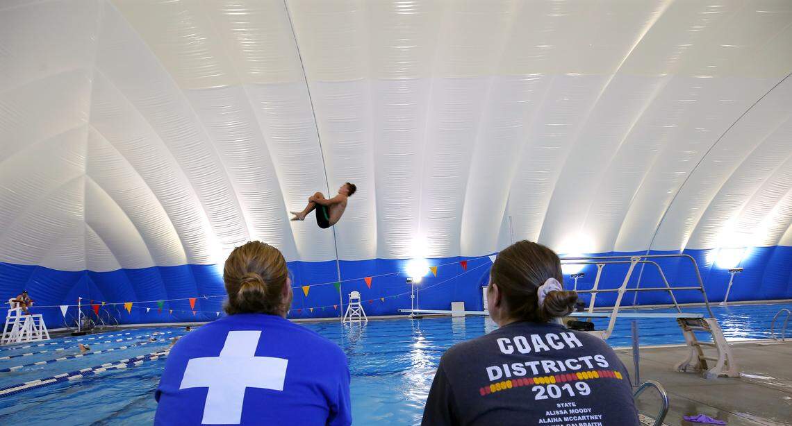 Richland dive coach Mitch Piper, left, and Pasco Kelsie Siegfried study their athletes as they practice recently inside the nearly $2 million bubble dome over the Olympic-sized pool at Pasco's Memorial Pool.  The dome towers at 38-feet high, 113-feet wide and 200-feet long is supported by air pressure.