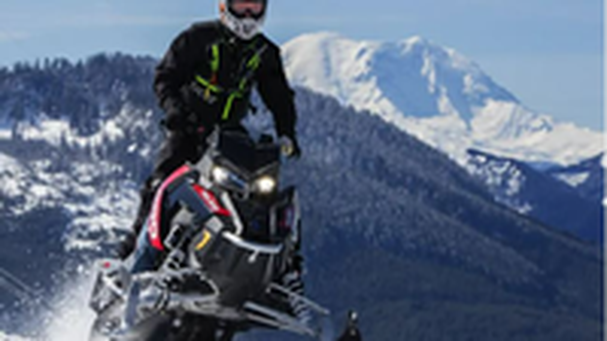 A snowmobiler powers through powder at a Washington Sno-Park.
