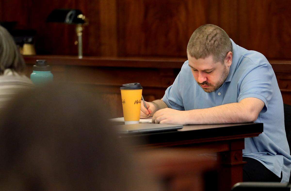 Murder suspect Joshua D. Davis appears to write notes Monday before the start of his first-degree murder trial in Franklin County Superior Court in Pasco.