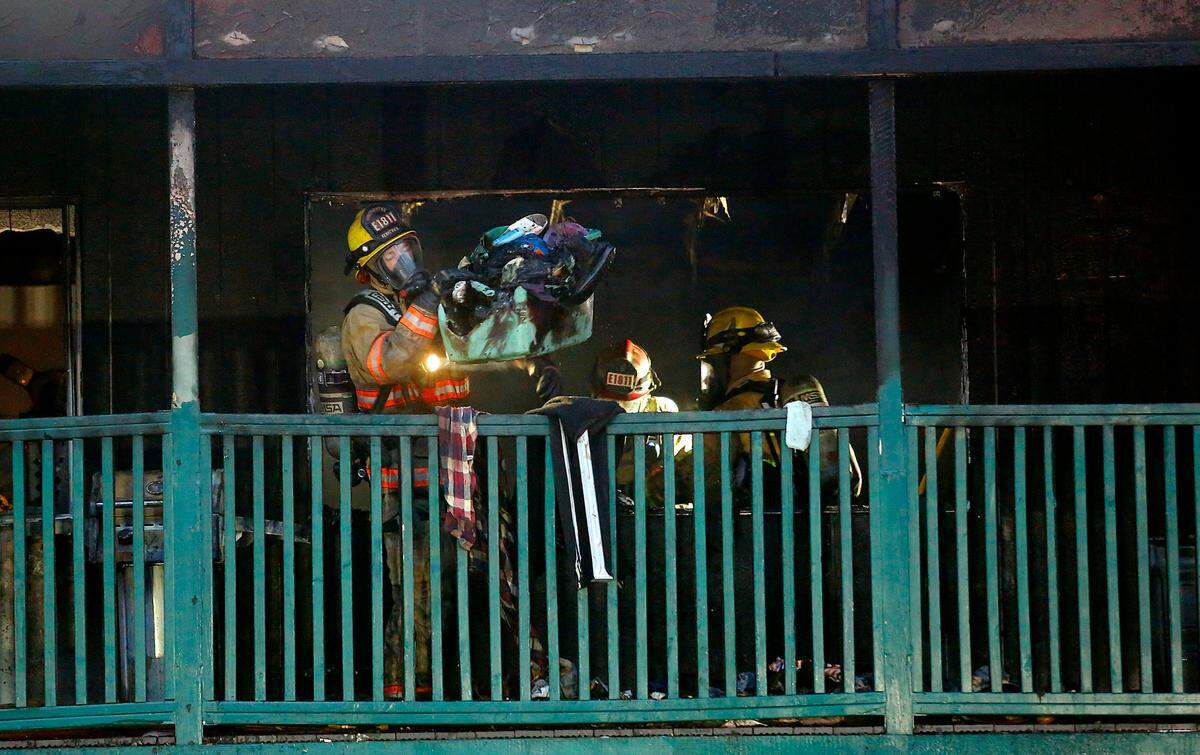 Kennewick firefighters remove charred and smoldering belongings from a fire damaged top floor apartment Thursday morning from at the 16-unit Breezeway Apartments complex on West Bruneau Place in Kennewick. Fire officials say no one was injured in the early-morning fire.