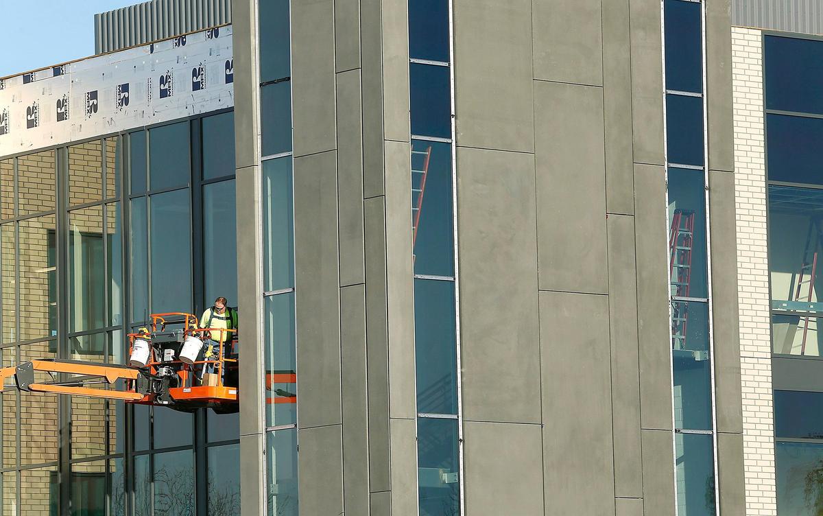 A construction workers uses a lift on the exterior of the new three-story, 40,000-square-foot city hall at 625 Swift Blvd. in central Richland. The new building is expected to be ready for employees in the spring.