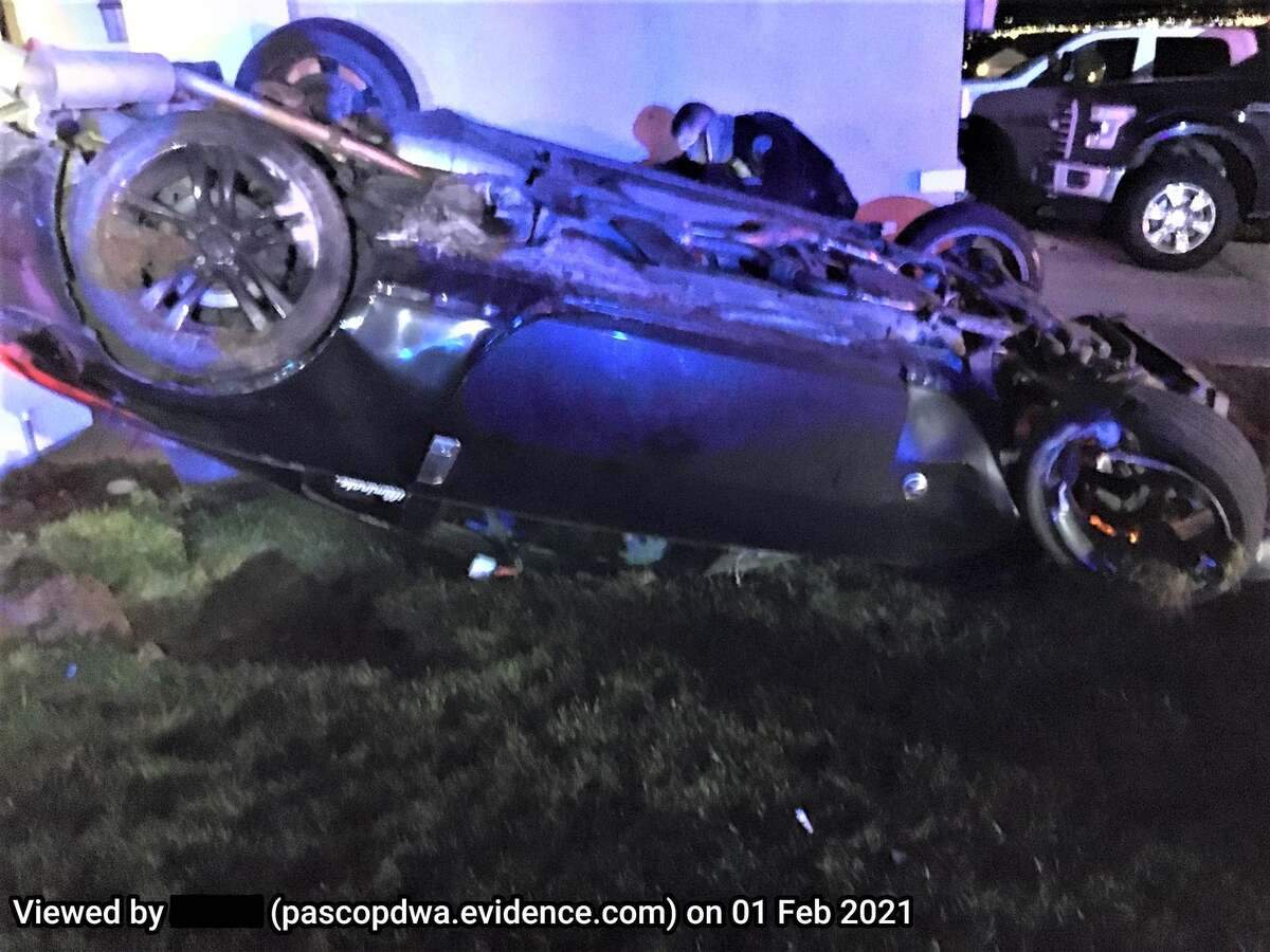 Two people had to be freed from a sports car after it rolled outside of a Pasco home Sunday night