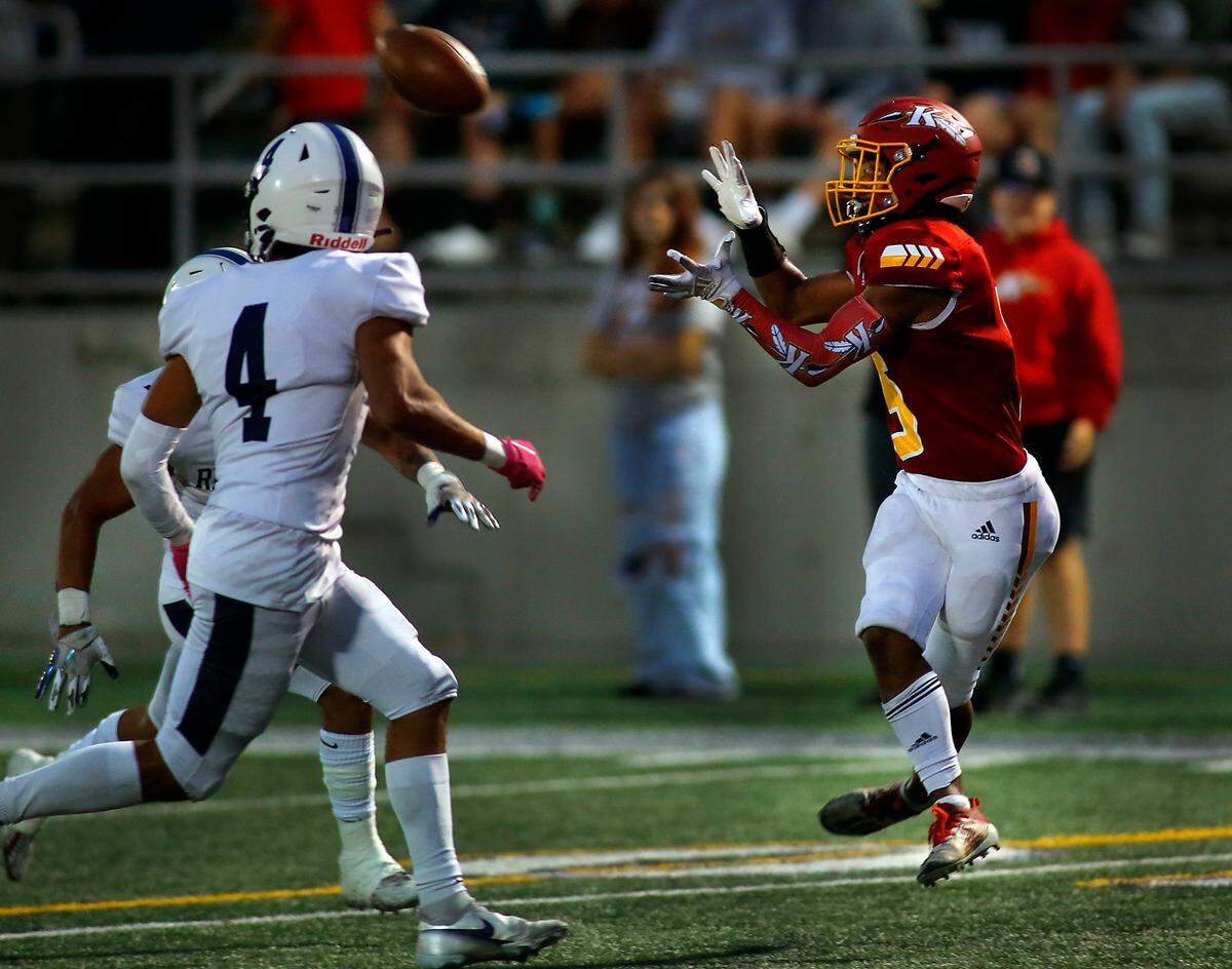 Kamiakin’s Aidan Canada hauls in a touchdown pass as Chiawana defender Pablo Flores (4) chases the play during Thursday’sgame at Lampson Stadium in Kennewick. The Braves won 46-24.