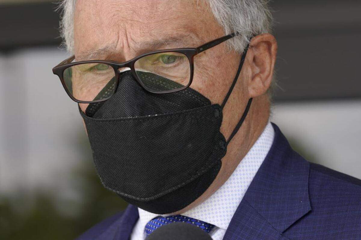 Washington Gov. Jay Inslee wears a mask as he talks to reporters outside a Dept. of Ecology office in Richland.