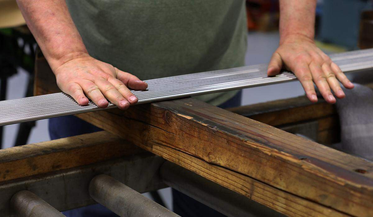 Workers at SIGN Fracture Care International in Richland inspect the long pieces of raw stainless steel for imperfections before they are manufactured into “nails” surgeons will use to treat long-bone injuries in remote areas of the world.