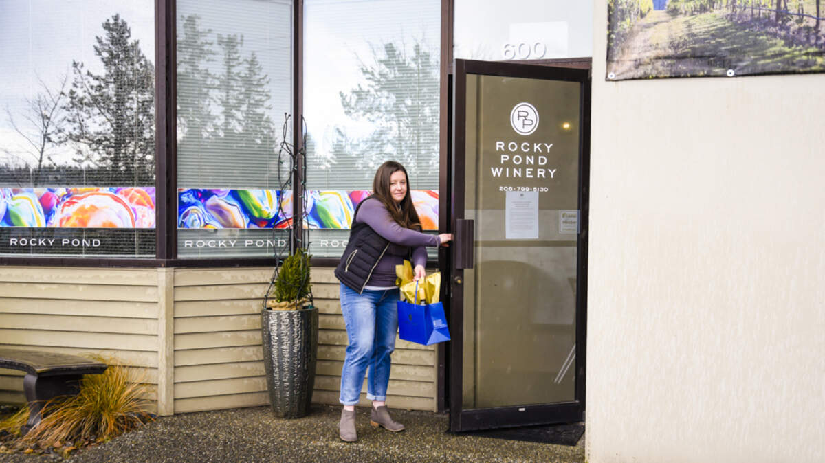 Rochelle Shawver, tasting room manager for Rocky Pond Winery in Woodinville, delivers a “winegram” to a customer in the Warehouse District, but she also is making deliveries to surrounding communities such as Ballard, Edmonds and Lynnwood.