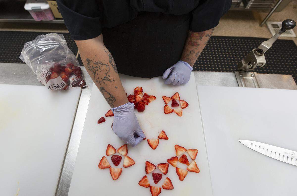 Steph “Kingdom” Ciulla, cuts up strawberries to put them on top of baklava and a New York styke cheese cake fusion.