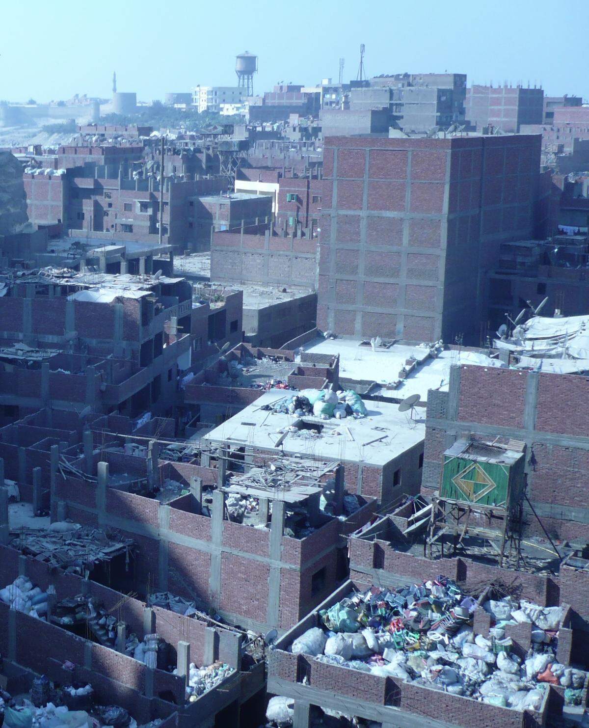In the narrow streets of Manshiyat Nasser, Egypt the stench of garbage is almost suffocating. Throngs of adults and children scurry about, sorting garbage in the streets, shops and homes, creating enormous, towering heaps of refuse.