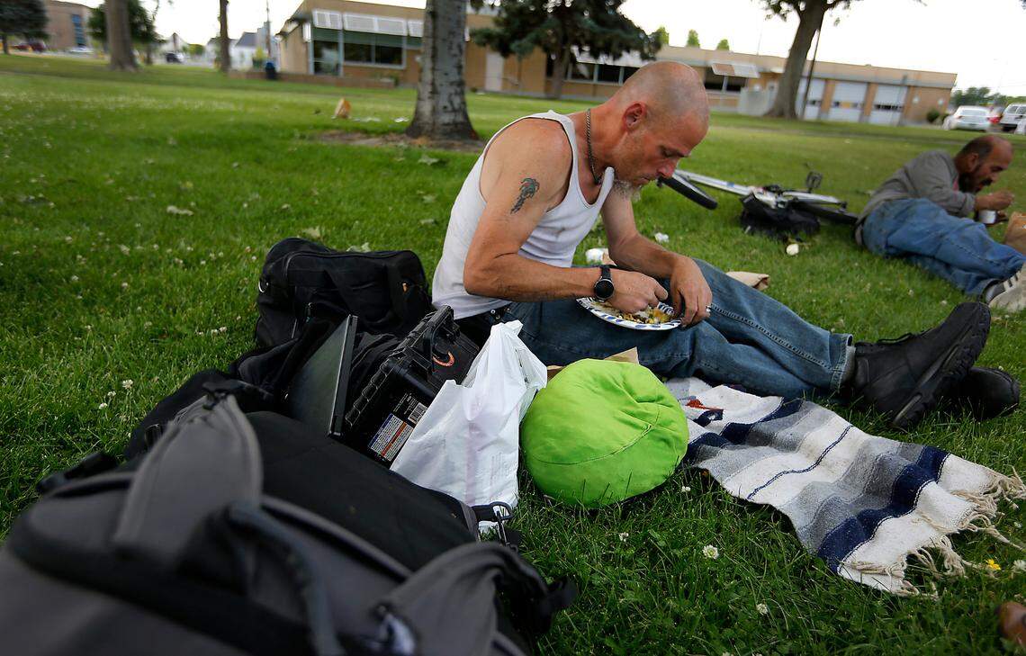 Chris Klein eats a free meal served weekly on June 7, 2023 to the homeless by a group of volunteers in Keewaydin Park in downtown Kennewick.