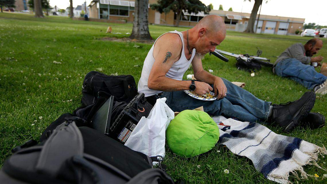 Chris Klein eats a free meal served weekly to the homeless and others by a group of volunteers in Keewaydin Park in downtown Kennewick. The funding used to boost homelessness prevention and housing programs in the Tri-Cities and across the nation largely ran out this summer.