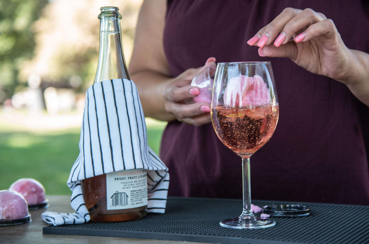 Criselda Davila demonstrates a La Cantina Mobile Bar specialty drink - a sparkling wine complete with homemade glitter cotton candy.
