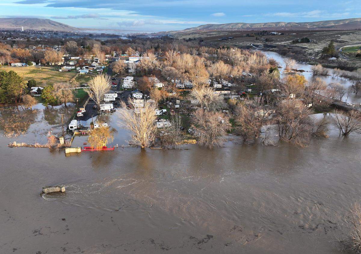 The swollen Yakima River has overflowed its banks and is flooding the Beach RV Park on Benton City. Many of the residents have moved their trailer to higher ground before the river's expected crest.