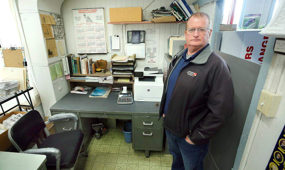 Keith Silliman stands near the desk and well-worn office chair his dad, Ken Silliman, was using as recently as last week in the office space area of Farmers Exchange in downtown Kennewick. Ken Silliman, who died Feb. 17, remained engaged with the business during the coronavirus pandemic by arriving in the evening after the store closed.