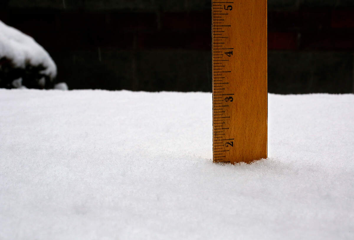 A ruler shows Monday’s spring snowfall approaching nearly 2 inches on a picnic table outside in south central Kennewick.