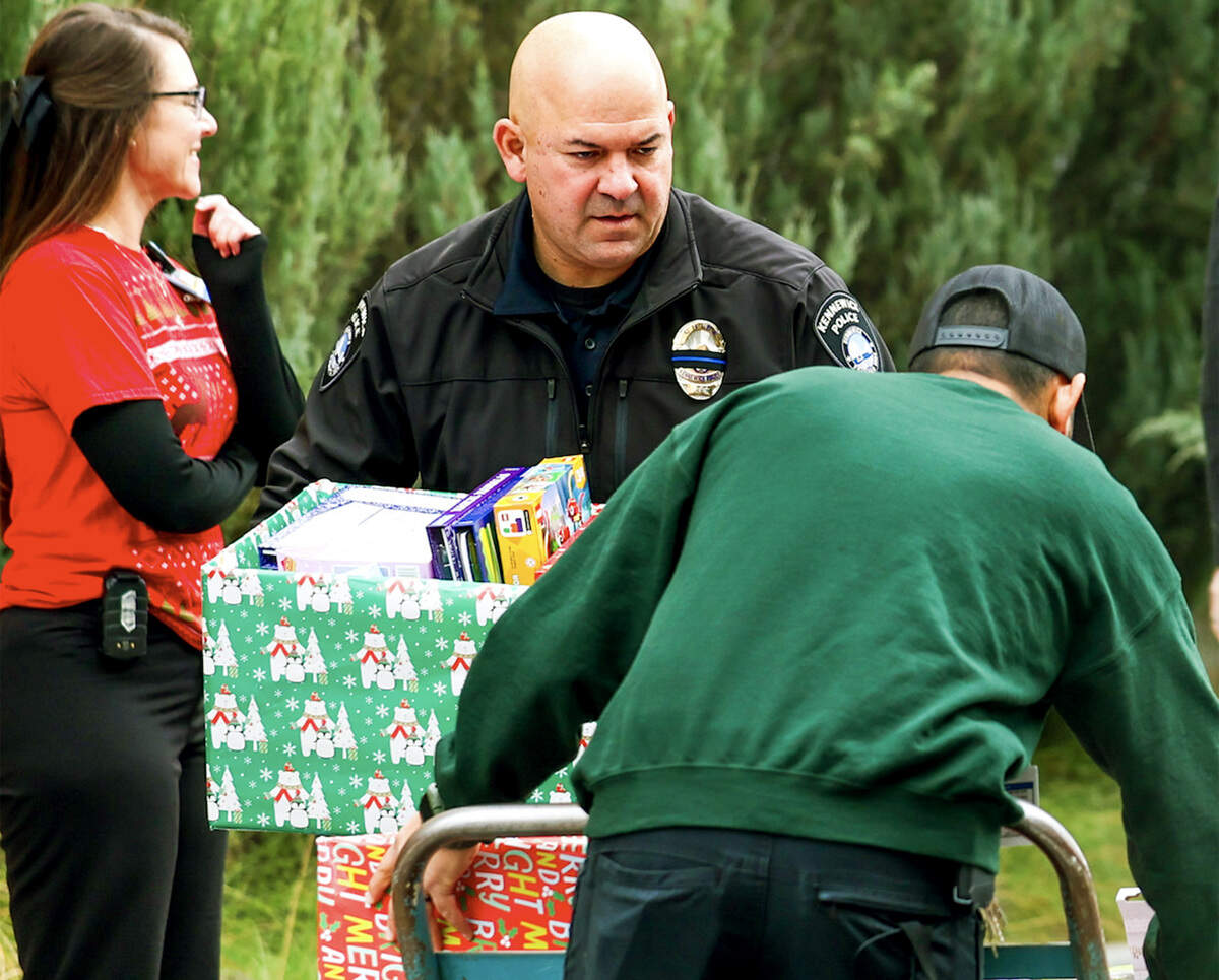 Kennewick Police Chief Chris Guerrero and volunteers help unload toys collected through the Kennewick Police Department Foundation donations and Adam and Jen’s Christmas Tree of Cash to donate to the Kadlec Regional Medical Center’s pediatrics unit to give presents to children and their families in the hospital in Richland during the Christmas holiday.