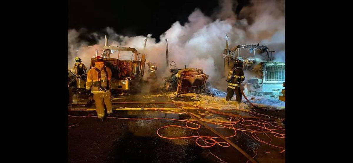 Fire crews battle a fire that destroyed seven trucks at Harms Pacific Transport.