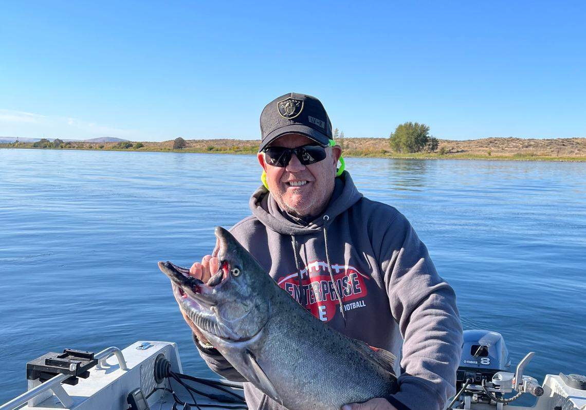 Tim Hilsen hoists a late-run upriver bright fall Chinook salmon caught in early October when the water was clear of aquatic plants.