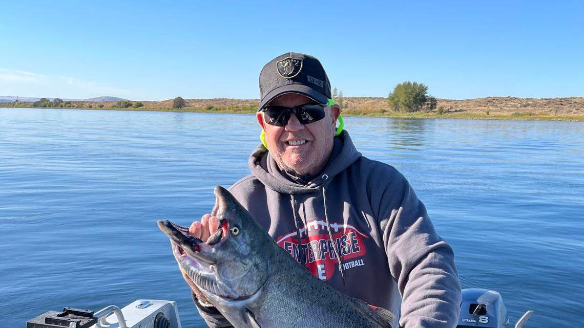 Tim Hilsen hoists a late-run upriver bright fall Chinook salmon caught in early October when the water was clear of aquatic plants.