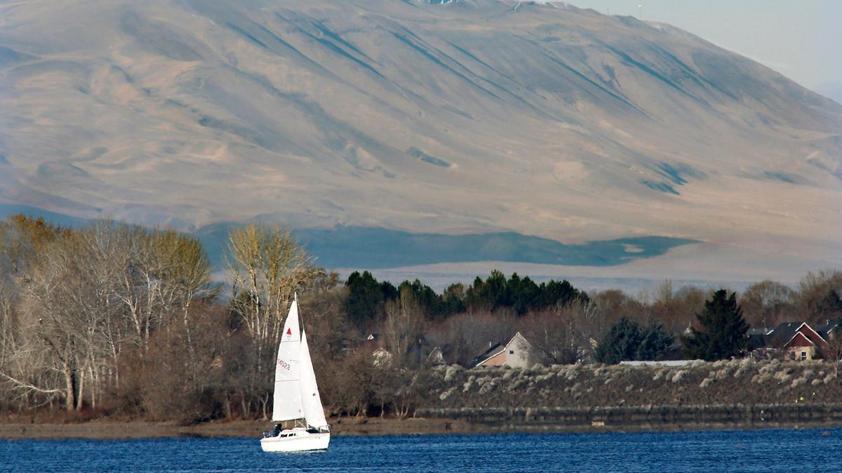 A sailboat takes advantage of Monday’s crisp breeze to make its way down the Columbia River close to the Franklin County shoreline with Rattlesnake Mountain as a backdrop for the excursion. The sunny conditions and clear skies are expected to give way to patchy freezing fog and temperatures dipping into the 20s on New Year’s Day morning and during overnight into Wednesday morning, according to the National Weather Service.