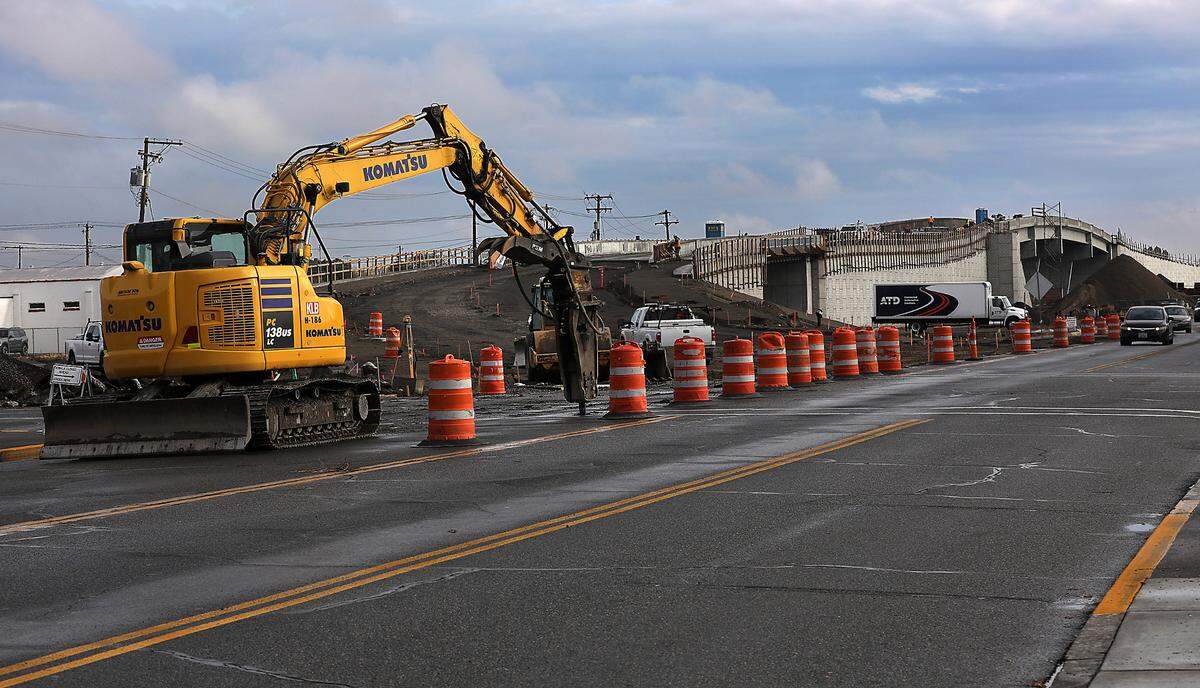 An excavator with a a jackhammer attachment breaks up asphalt at the intersection of West Lewis Street and North 2nd Avenue recently near the west end of the new Lewis Street overpass in Pasco.