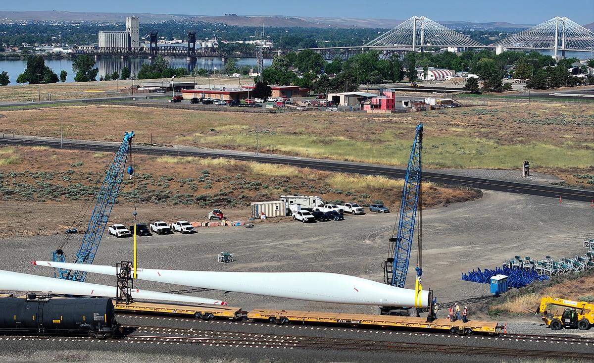 Workers rig straps around wind turbine blades to lift them off train cars near Oregon Avenue in Pasco.