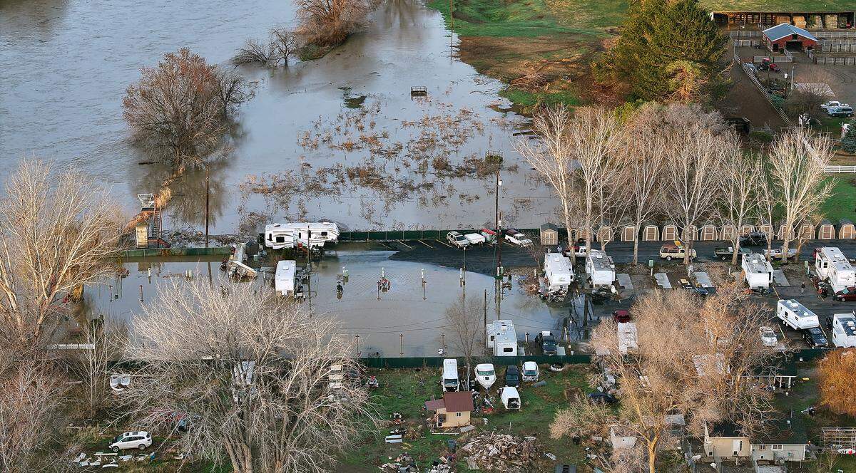 The swollen Yakima River has overflowed its banks and is flooding the Beach RV Park on Benton City. Many of the residents have moved their trailer to higher ground before the river's expected crest.