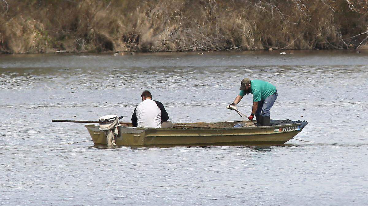 A pair of fishermen check a gill net from a small john boat recently in the shallow backwaters of the Yakima River near Bateman Island in Richland. They are legally permitted through the Washington Department of Fish & Wildlife for the commercial harvest of carp, according WDFW officer Jon Horn.