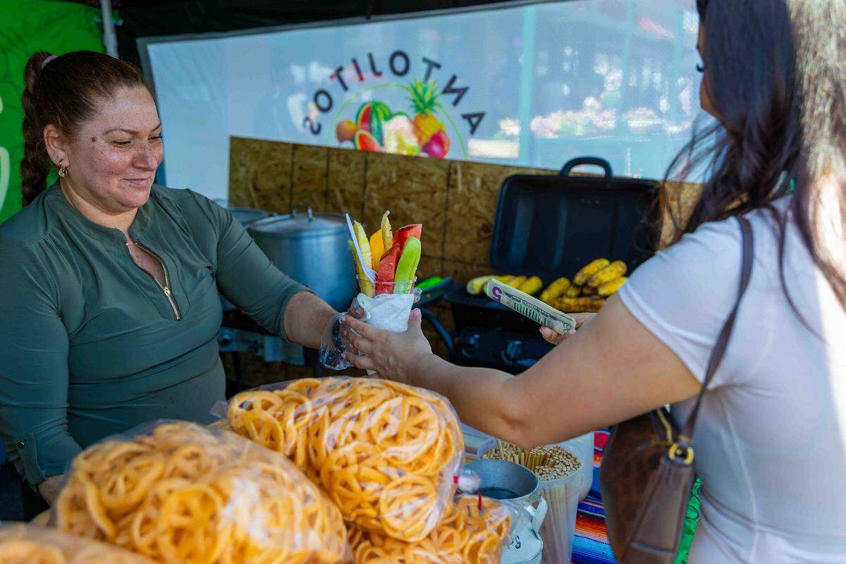A food vendor serves fresh fruit and grilled corn to festival-goers during Pasco’s Cinco de Mayo celebration on Saturday in downtown Pasco.