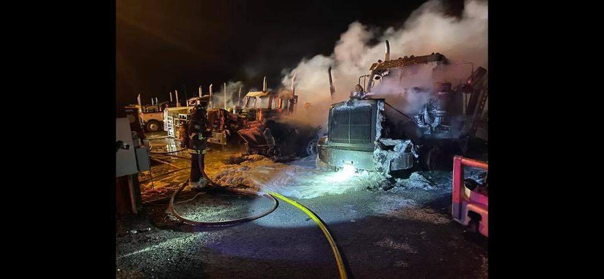 Fire crews battle a fire that destroyed seven trucks at Harms Pacific Transport.