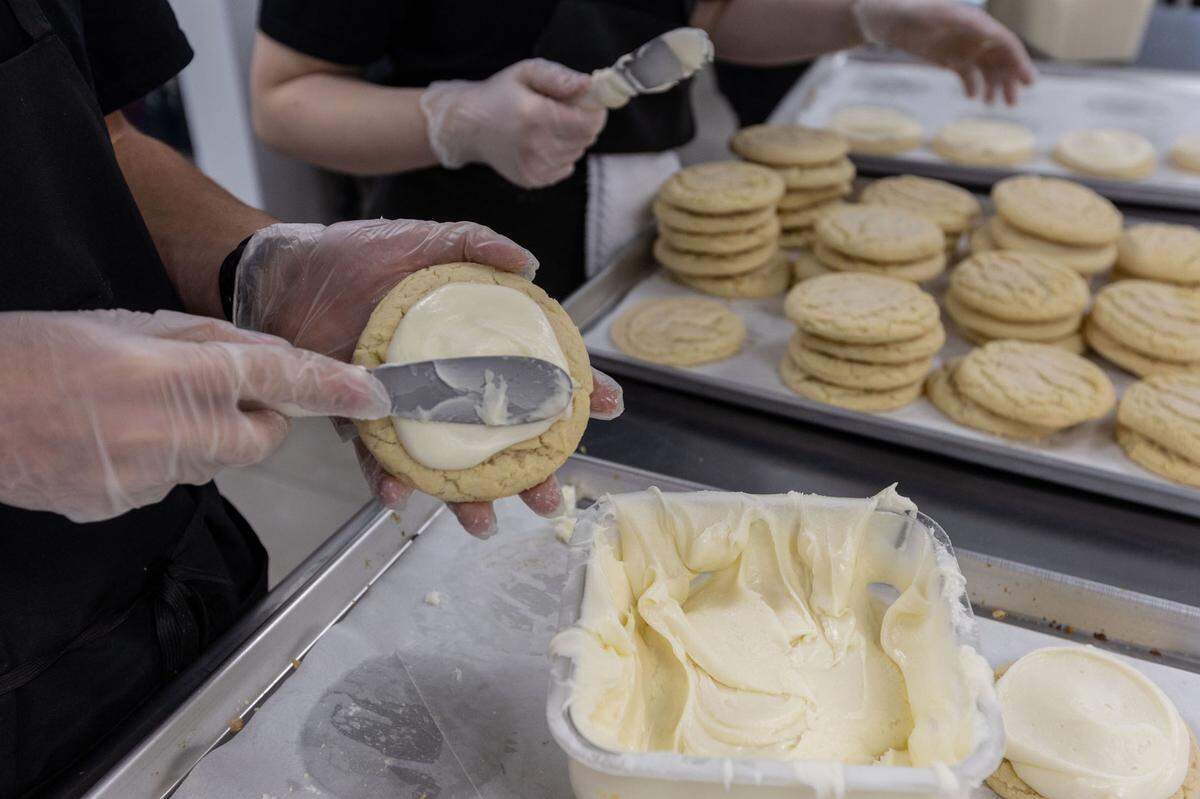 Workers ice sugar cookies at Crumbl Cookies in Kennewick. The popular chain made its Tri-Cities debut in Richland in March and will soon have locations in all three cities, with a third set to open in Pasco off of Road 68.