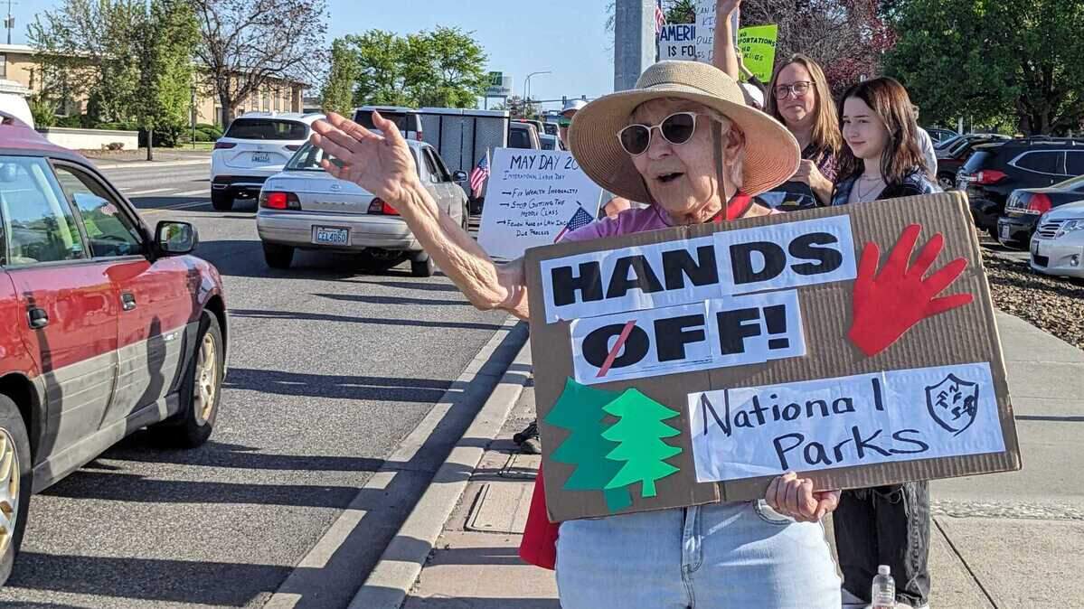 Tanya Lasuk, 73, of Kennewick, is the first to greet 5 p.m. commuters during a May Day protest held Thursday, May 1, at John Dam Plaza. About 400-500 came out to the event hosted by Indivisible Tri-Cities.